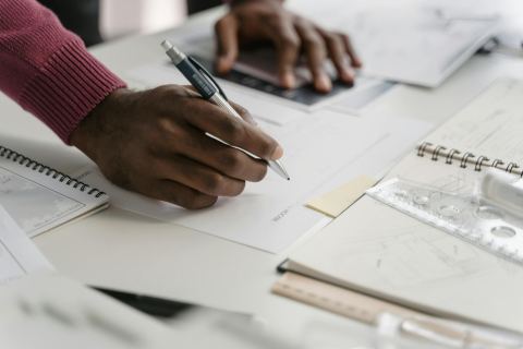 Close-up of a person reviewing construction plans before a remodeling estimate.