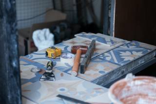 Flooring and tile installation reference with tools and tile on a construction surface.