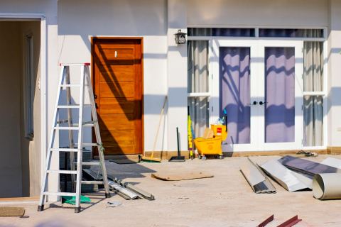 A front entrance of a house under renovation with tools and materials.