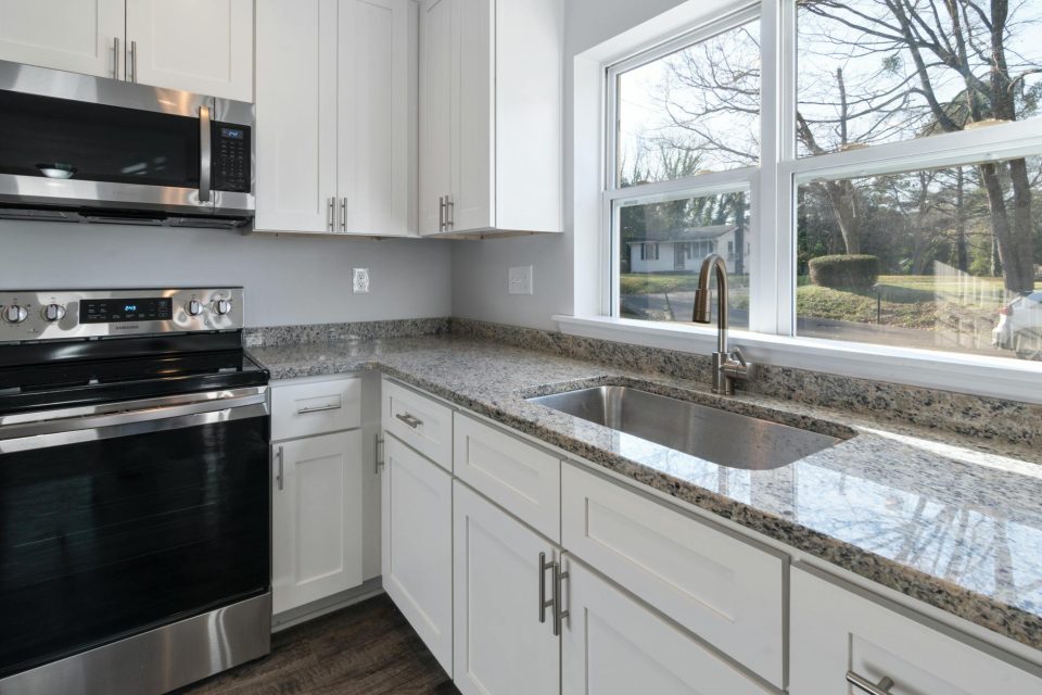 Bright kitchen remodeling reference with counters, appliances, and large windows.