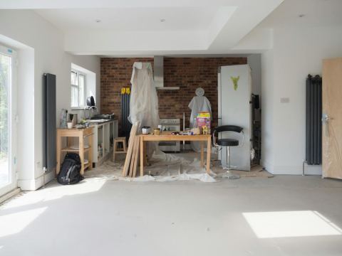 A bright kitchen extension under renovation with tools and materials.