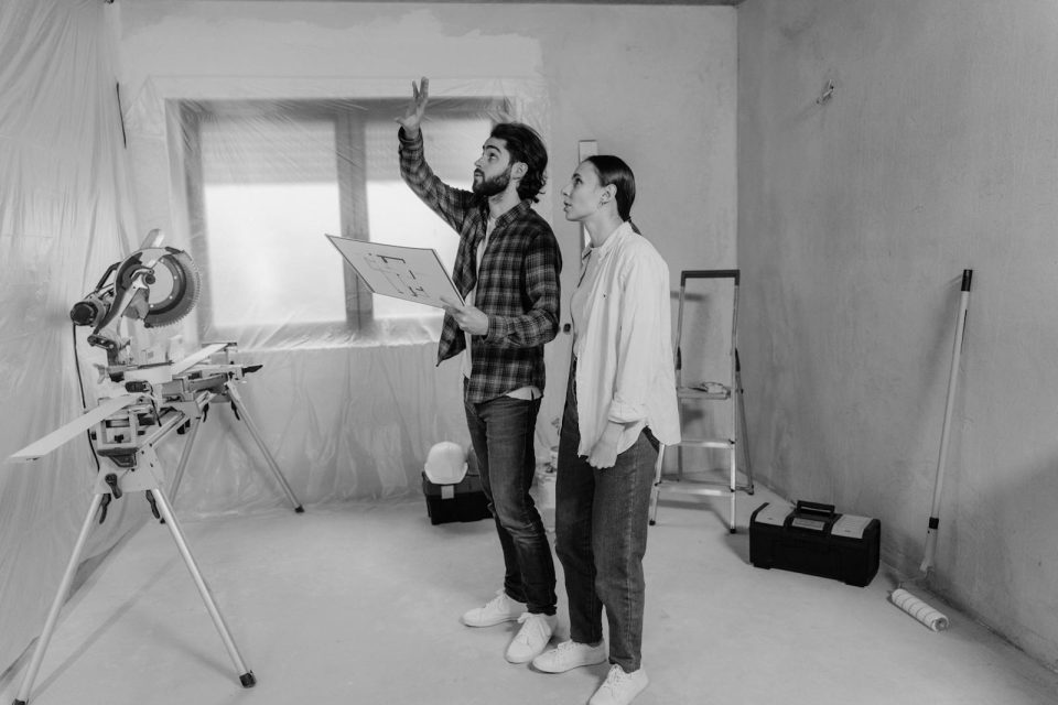 Two people reviewing home improvement plans and construction drawings.