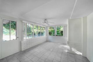 Sunroom addition reference with large windows, tiled floor, and natural light.